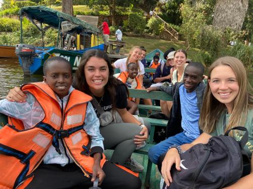 a group of people sitting on a boat on the water at Nyamunyonyi Lake Resort in Kabale