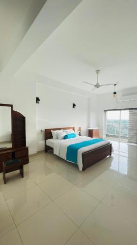 - une chambre avec un lit, une commode et une télévision dans l'établissement Luxe Highway Residencies, à Kottawa
