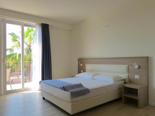 a bedroom with a bed and a large window at Salinello Village in Tortoreto Lido