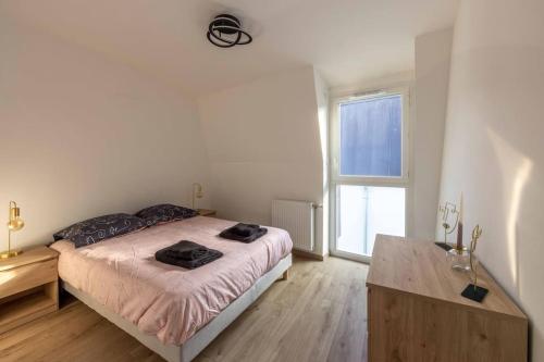 um quarto com uma cama e uma grande janela em Les Jardins d'Aix em Aix-les-Bains