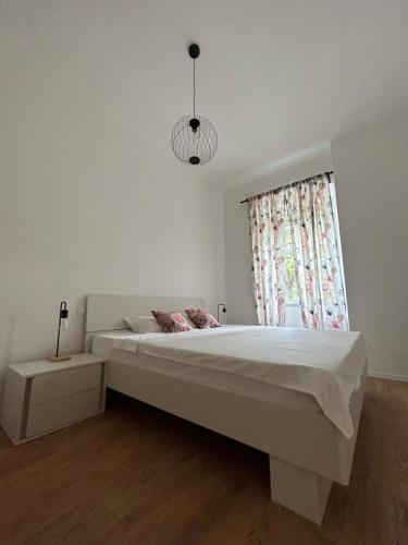 a white bedroom with a large bed and a window at Nina & Lola in Rijeka