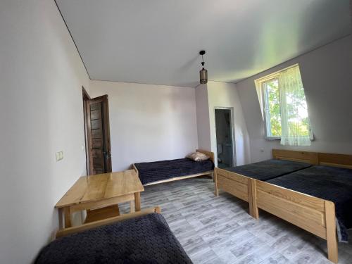 a room with two beds and a table and a window at Batita in Kobuleti