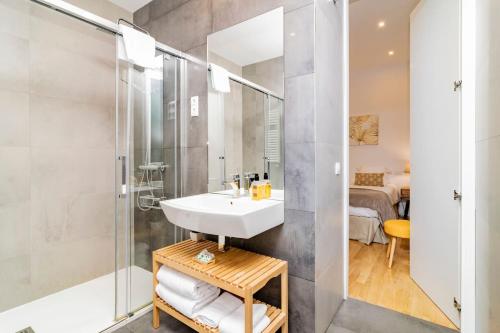 y baño con lavabo y ducha. en Juan Bravo Suites en Madrid