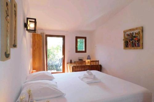 une chambre blanche avec un lit et une fenêtre dans l'établissement Villa pour 5 personnes avec jardin et piscine privée, à Villeneuve-Loubet
