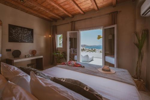 una camera da letto con un letto grande e una grande finestra di Legends in Town, by Mykonos High a Mykonos Città
