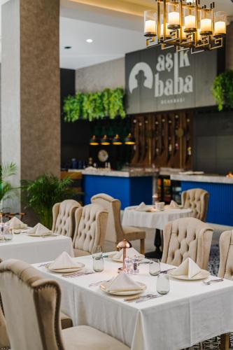 a dining room with white tables and chairs at The Arkin Iskele in Iskele