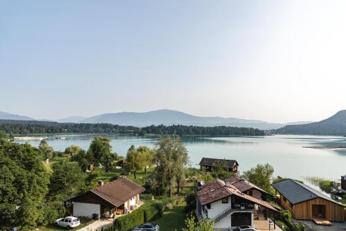 a view of a lake with houses and cars at Hotel Faaker See Inn by S4Y in Faak am See