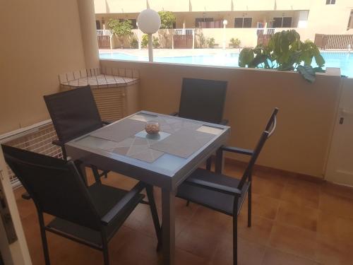 a dining room with a table and chairs and a pool at Medano Loft in El Médano