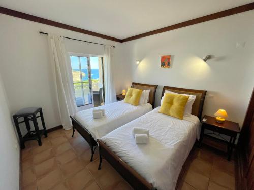 two beds in a room with a window at Terraços de Benagil By Lemúria in Carvoeiro