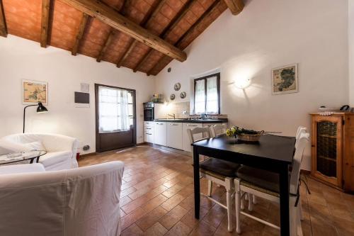 ein Wohnzimmer mit einem Tisch und einer Küche in der Unterkunft Villa Le Ripe Apartments in Gambassi Terme