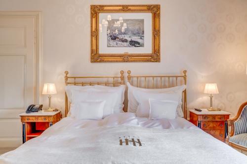 a bedroom with a large white bed with two tables at Grand Hotel National Luzern in Luzern