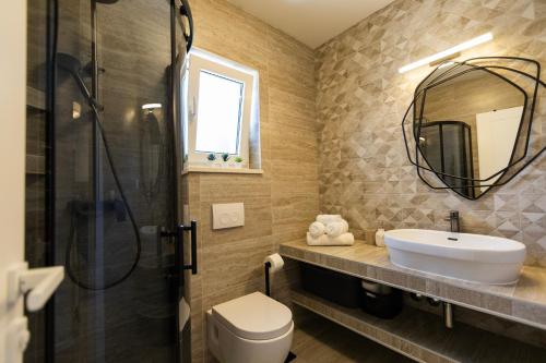 y baño con lavabo, aseo y espejo. en Villa Kiara, en Kaštela