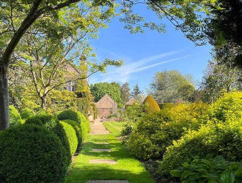 a garden with green hedges and a pathway at Fischers Baslow Hall - Chatsworth in Baslow
