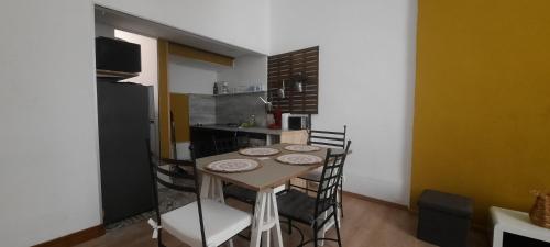 une cuisine avec une table et des chaises dans une pièce dans l'établissement New Le 7 Clim Central Calme Parking Volumes, à Carcassonne