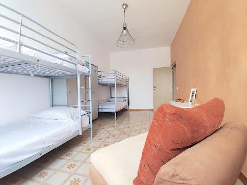 a bedroom with two bunk beds and a couch at Eco House San Michele in San Michele