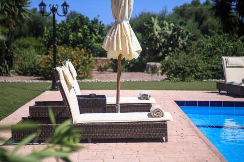 a patio umbrella and chairs next to a pool at Villa Hestia - Seaview Serenity Villa with Private Pool by Villa Mana Gers in Kipseli