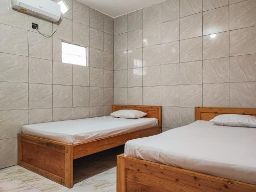 um quarto com duas camas e uma janela em Reddoorz Syariah Near Kantor Gubernur Jambi em Jambi
