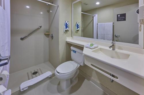 a bathroom with a toilet and a sink and a mirror at City Express Plus by Marriott Reforma El Ángel in Mexico City
