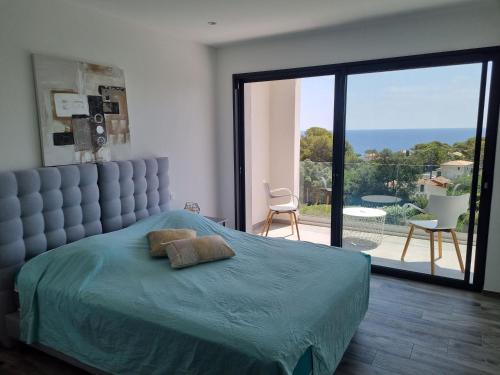 - une chambre avec un lit et une grande porte en verre dans l'établissement Cap malouins, à Saint-Peïre-sur-Mer