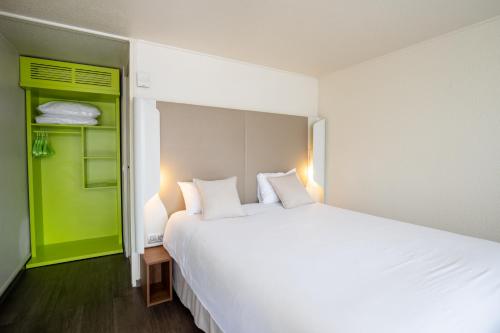 a bedroom with a large white bed and a green closet at Campanile Reims Ouest - Tinqueux in Reims