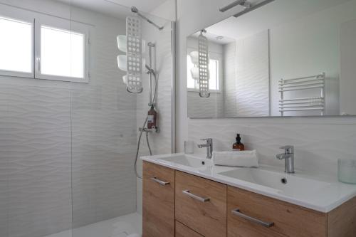 une salle de bain avec un lavabo, une douche et un miroir dans l'établissement Lulli - Spacieux appartement en rez de jardin, à Arcachon