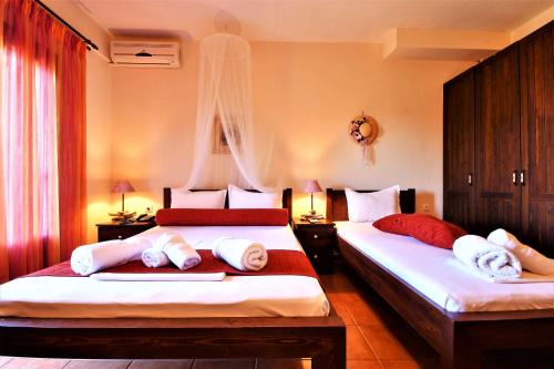 two beds in a hotel room with towels on them at Guesthouse Amanitis Caesarea in Skíti