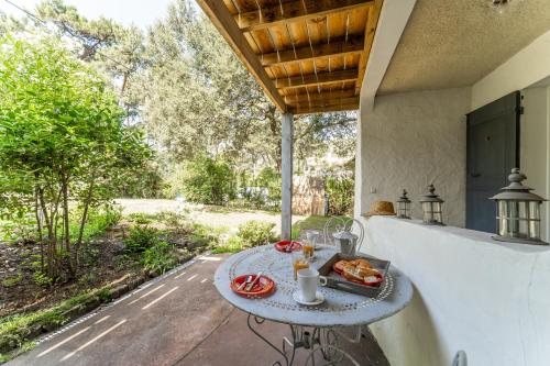 - une table avec un plateau de nourriture sur la terrasse dans l'établissement Lulli - Spacieux appartement en rez de jardin, à Arcachon