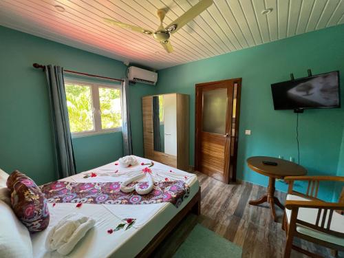 a bedroom with a bed and a television and a table at Chloe's Cottage Self-Catering in La Digue