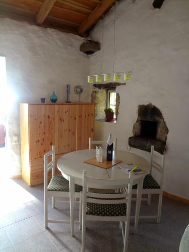 comedor con mesa, sillas y horno en Casa dos Sonhos, en Fajazinha