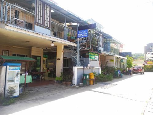 - un bâtiment avec balcon sur le côté d'une rue dans l'établissement Nu Phuket Airport Resident 1, à Nai Yang Beach