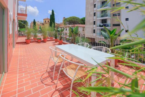een witte tafel en stoelen op een patio bij Terra Aurea Aparthotel in Salou