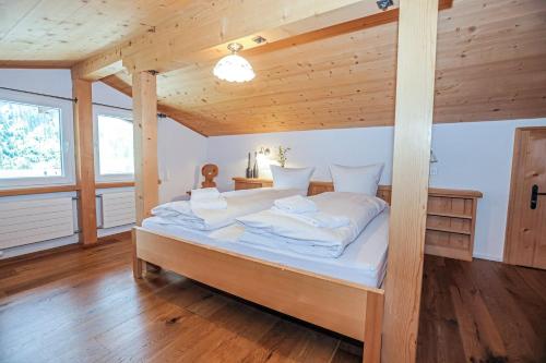 ein großes Bett in einem Zimmer mit Holzdecke in der Unterkunft Casa LA RODA in Sedrun
