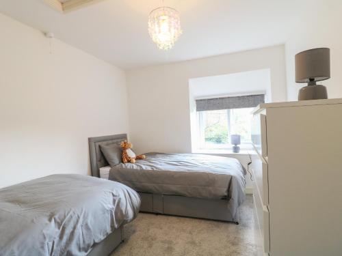 a bedroom with two beds and a window at Midway Cottage in Matlock