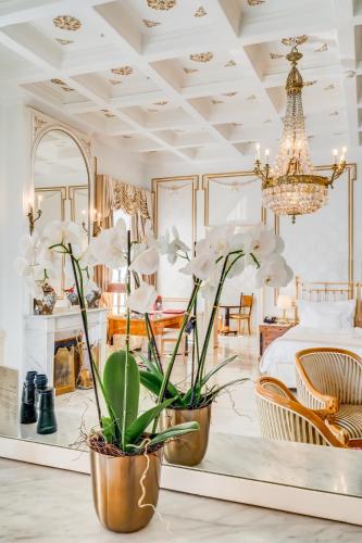 a bedroom with a bed and a chandelier at Grand Hotel National Luzern in Luzern