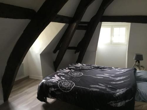 um quarto com uma cama com um edredão preto em Bel appartement dans petite citée de caractère em Tréguier