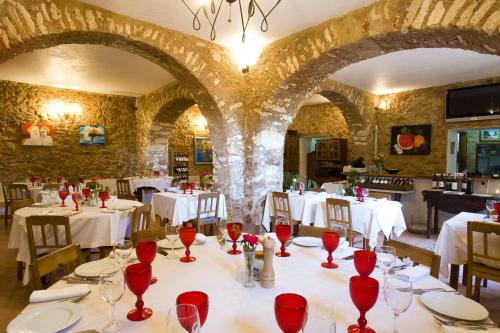 a dining room with white tables and red wine glasses at Hospedaria Moiras Encantadas in Paderne