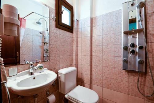 y baño con aseo blanco y lavamanos. en Guesthouse Amanitis Caesarea, en Skíti
