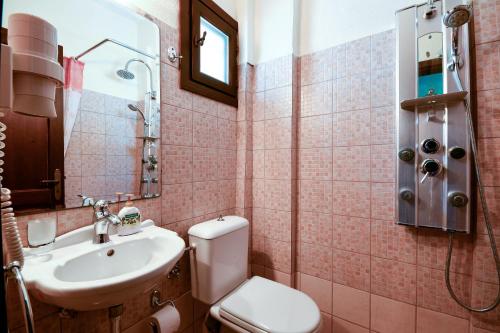 a bathroom with a white toilet and a sink at Guesthouse Amanitis Caesarea in Skíti