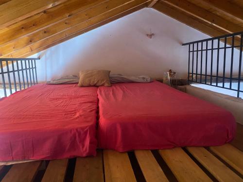 a large red bed in a room with wooden floors at Eva's house in Mythimna