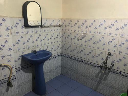 La salle de bains est pourvue d'un lavabo bleu et d'un miroir. dans l'établissement B Hostel, à Fort Kochi