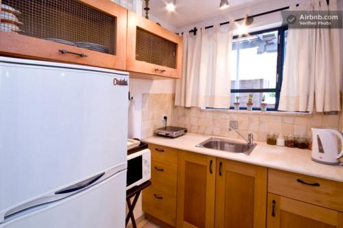 a kitchen with a white refrigerator and a sink at Villa Tivon in Oranim