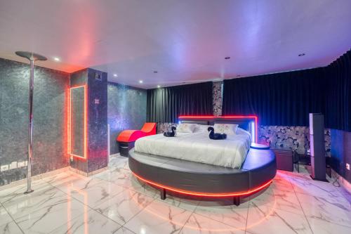 een slaapkamer met een groot bed in een kamer met blauwe muren bij Love Room Attitude in Grenoble