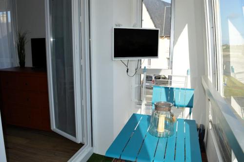 a blue table with a glass jar on top of it at Le petit Courseulles - entre le port et la mer in Courseulles-sur-Mer