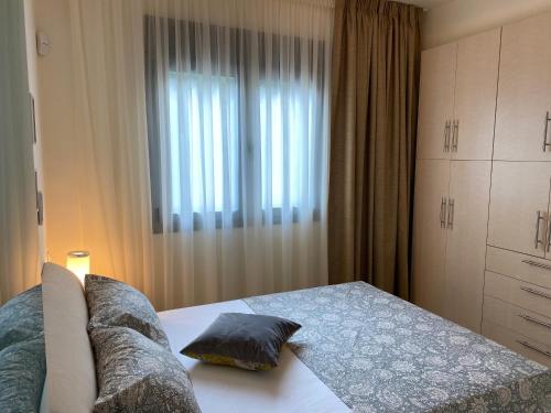 a bedroom with a bed and a window at Elounda Beach View House in Epáno Eloúnda