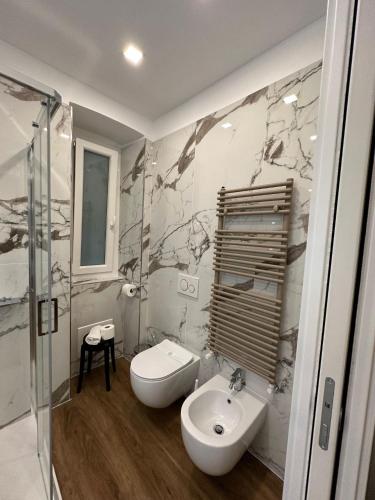 a white bathroom with a sink and a toilet at Sweet Rooms in La Spezia