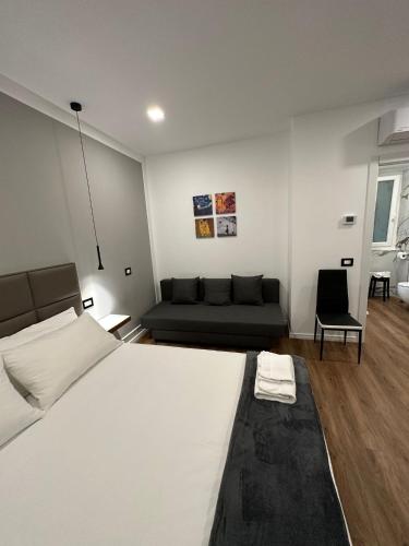 a bedroom with a large white bed and a couch at Sweet Rooms in La Spezia
