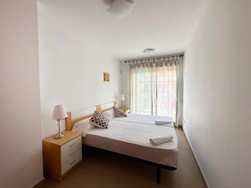 a small bedroom with a bed and a window at Apartamentos Alcocebre Suites 3000 in Alcossebre