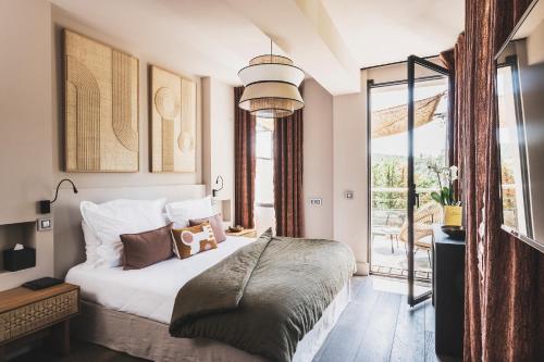 - une chambre avec un lit et une grande fenêtre dans l'établissement Les Lodges Sainte-Victoire Hotel & Spa, à Aix-en-Provence