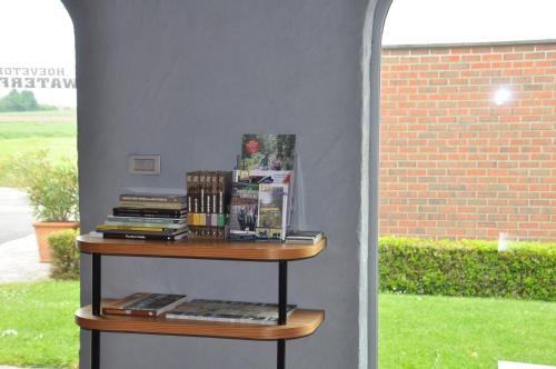 une étagère avec des livres à côté d'un mur dans l'établissement B&B Waterfields, à Zonnebeke