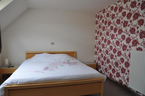 ein Schlafzimmer mit einem Bett mit einem roten und weißen Muster in der Unterkunft B&B Waterfields in Zonnebeke